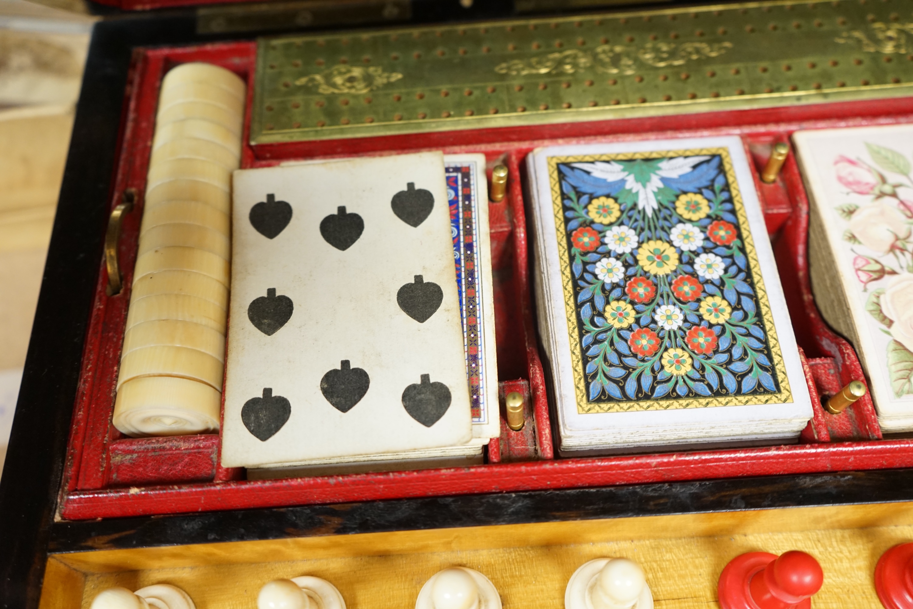 A Victorian coromandel games box with accessories, ivory chess pieces and counters, box 36cm wide x 19cm high. Condition - red interior leather worn and torn in places and box scratched, minor losses to chess pieces. CIT